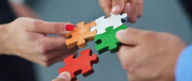 Group of business people assembling jigsaw puzzle